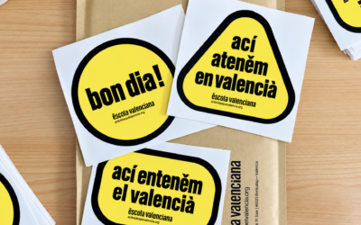 Escola Valenciana repartix adhesius gratuïts per a fomentar el valencià als comerços